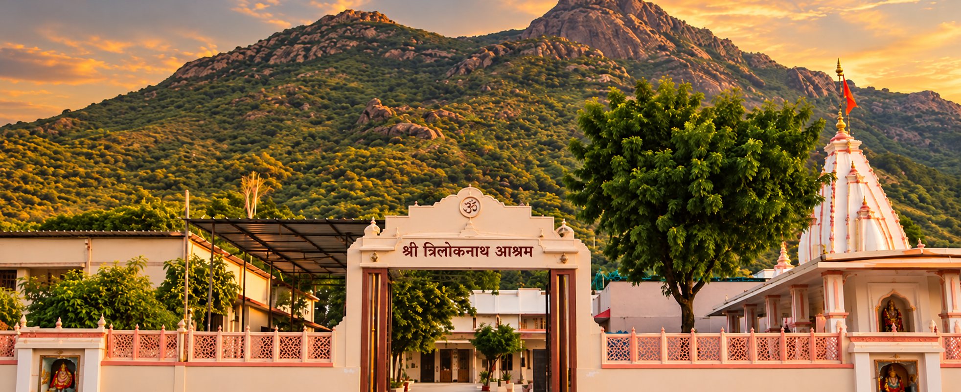 Shri Triloknath Ashram gate at golden hour with the Girnar hills behind